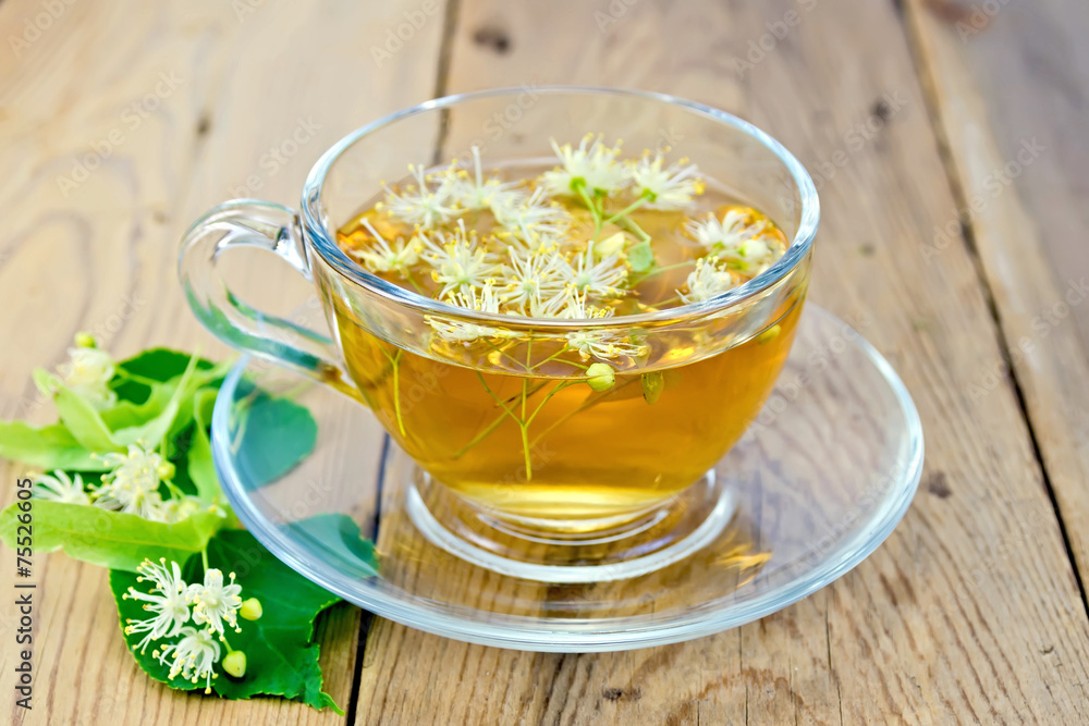 Herbal tea of linden flowers in glass cup on board Herbal tea of linden flowers in glass cup on board