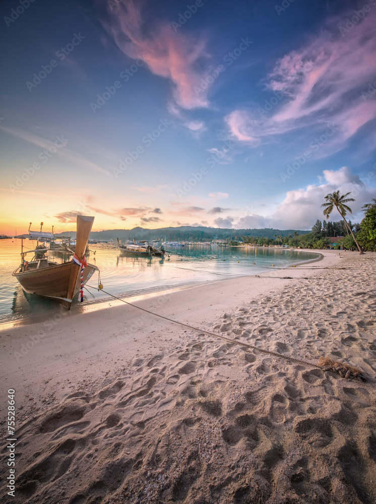 Naklejka premium sunset with colorful sky and boat on the beach