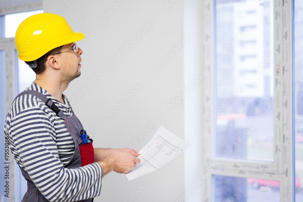 Foreman with construction plan in new building interior