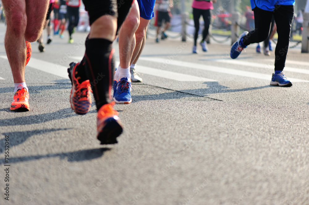 marathon athletes legs running on city road