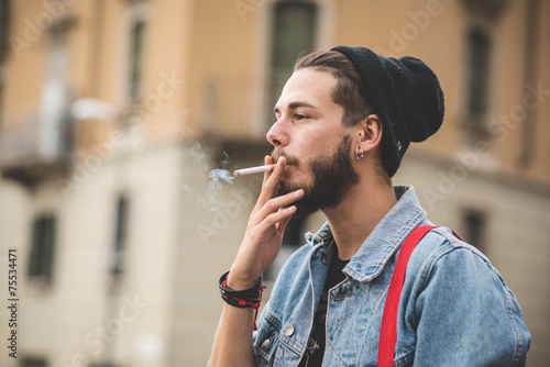 young handsome bearded hipster man smoking cigarette