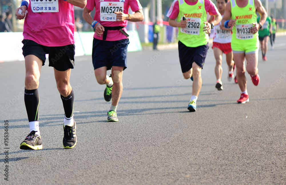 marathon athletes legs running on city road marathon athletes legs running on city road