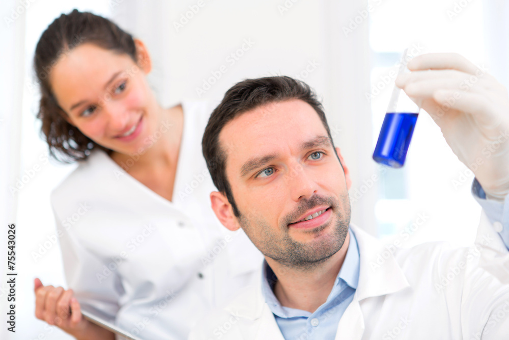 Scientist and his assistant working in a lab Scientist and his assistant working in a lab
