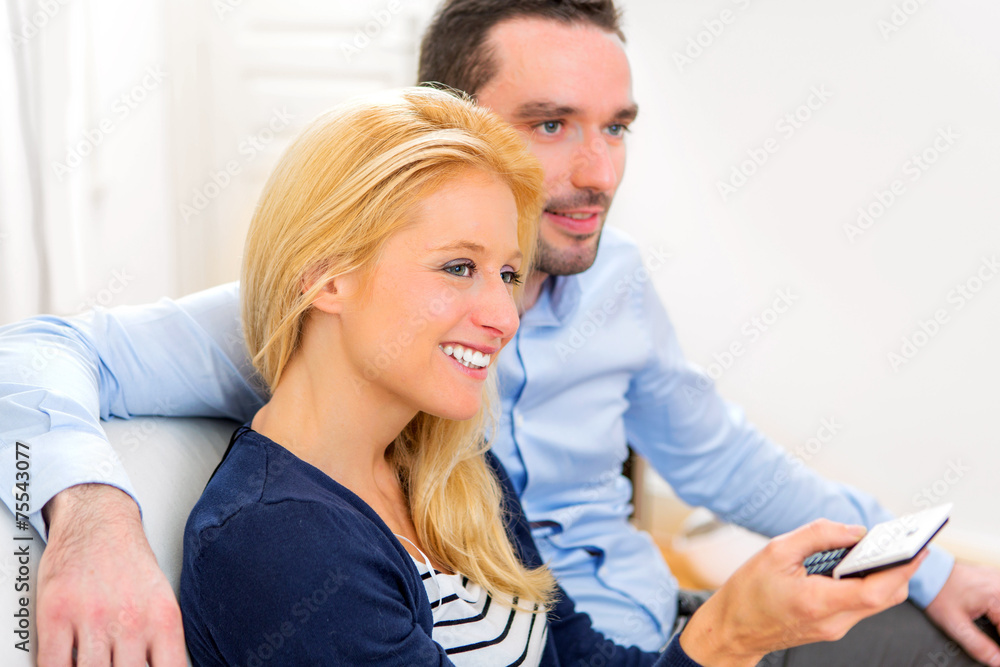 Young attractive couple watching tv