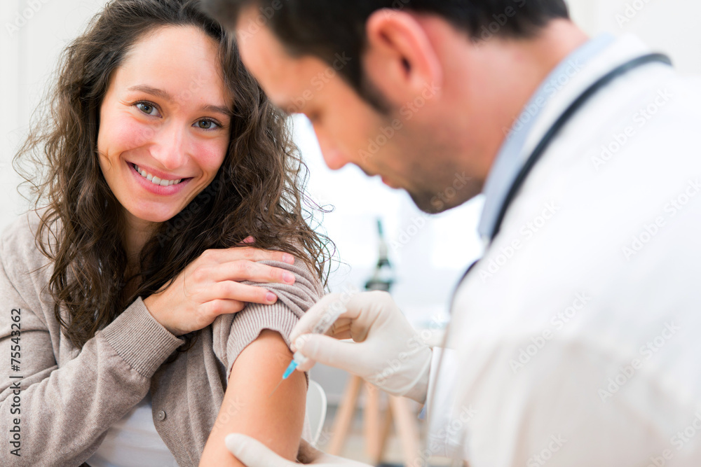 Young attractive woman being vaccinated