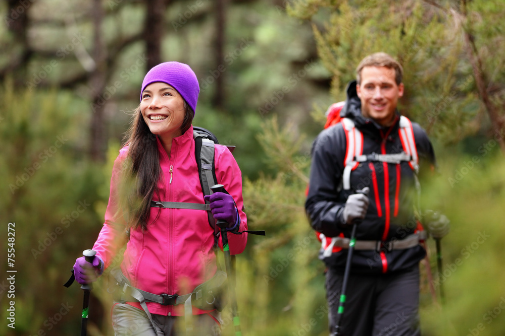 Hiking people - hikers trekking in forest on hike Hiking people - hikers trekking in forest on hike