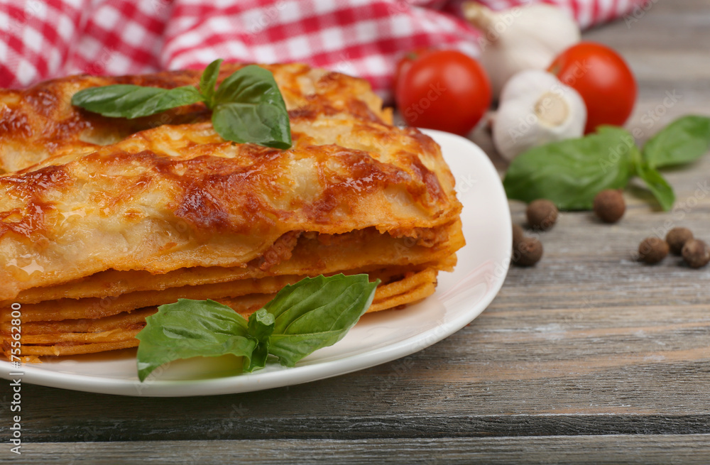 Portion of tasty lasagna on wooden table Portion of tasty lasagna on wooden table