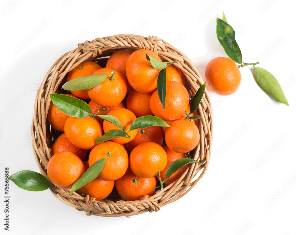 Mandarins in a wicker basket with green leaves Mandarins in a wicker basket with green leaves