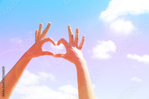 Young woman's hands making heart shape frame