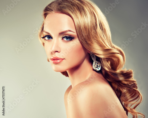 Fotografie Beautiful model blond with curly hair and fashion earings