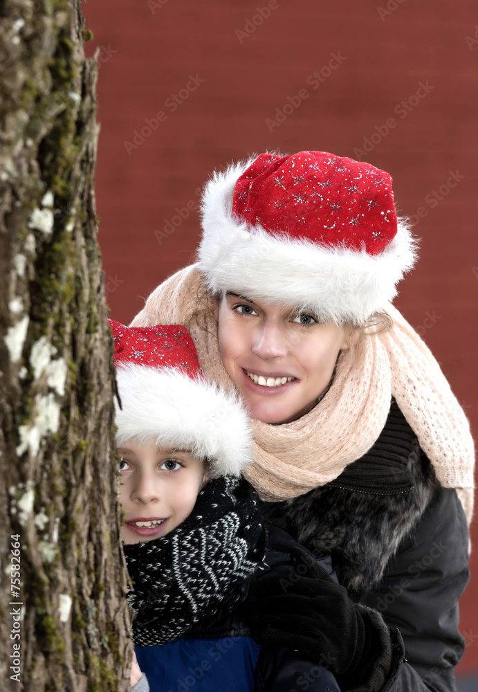 Frohe Weihnachten - Mutter und Sohn mit Weihnachtsmützen Frohe Weihnachten - Mutter und Sohn mit Weihnachtsmützen