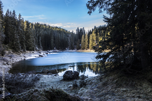 Carezza lake in winter with frosty surface