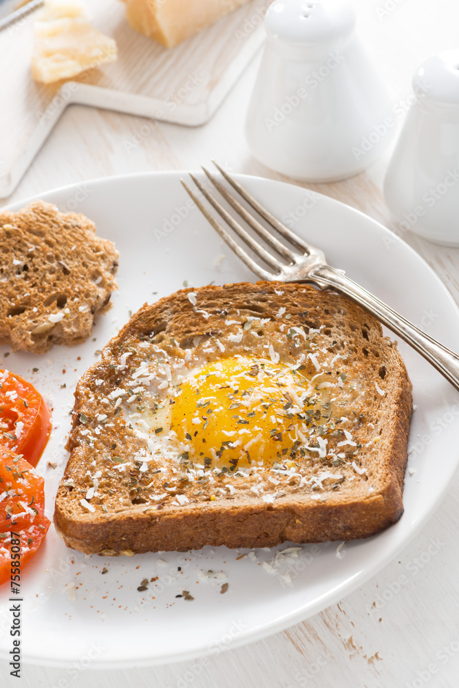 fried egg in a toast and grilled tomatoes, vertical fried egg in a toast and grilled tomatoes, vertical