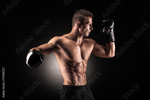 Muscular man in studio on dark background