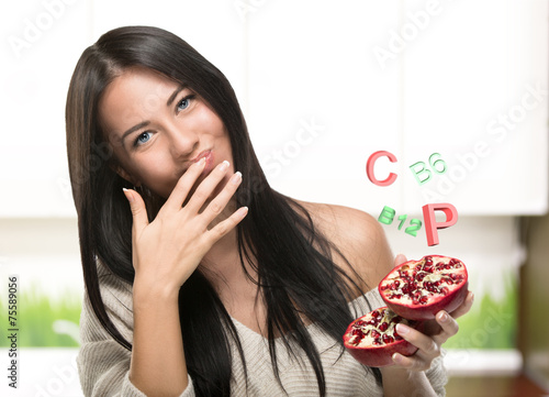 Brunette girl holding a Pomegranate in kuhne photo