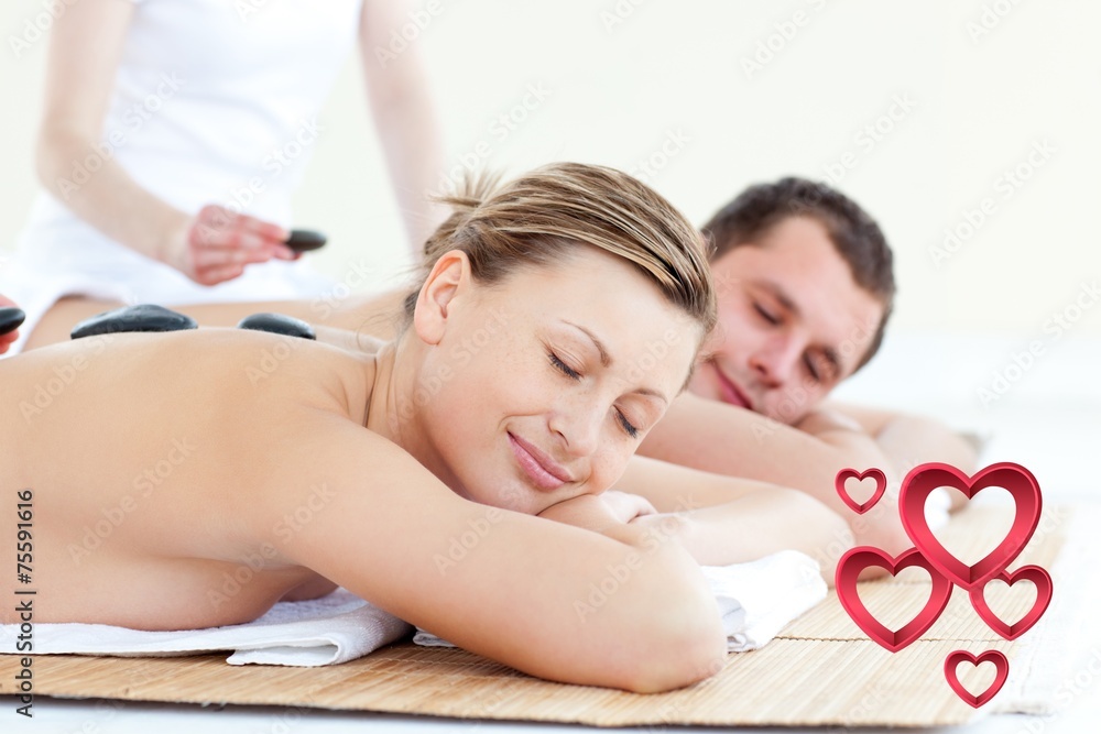 Composite image of young couple having a massage with hot stone - obrazy, fototapety, plakaty 