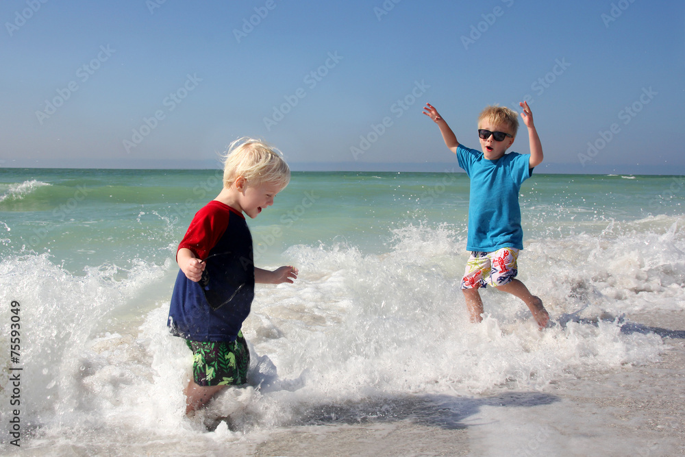 Two Young Children Playing and Splashing in Ocean Water Two Young Children Playing and Splashing in Ocean Water