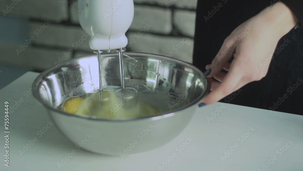 Mixing egg cream in bowl with motor mixer, baking cake Mixing egg cream in bowl with motor mixer, baking cake