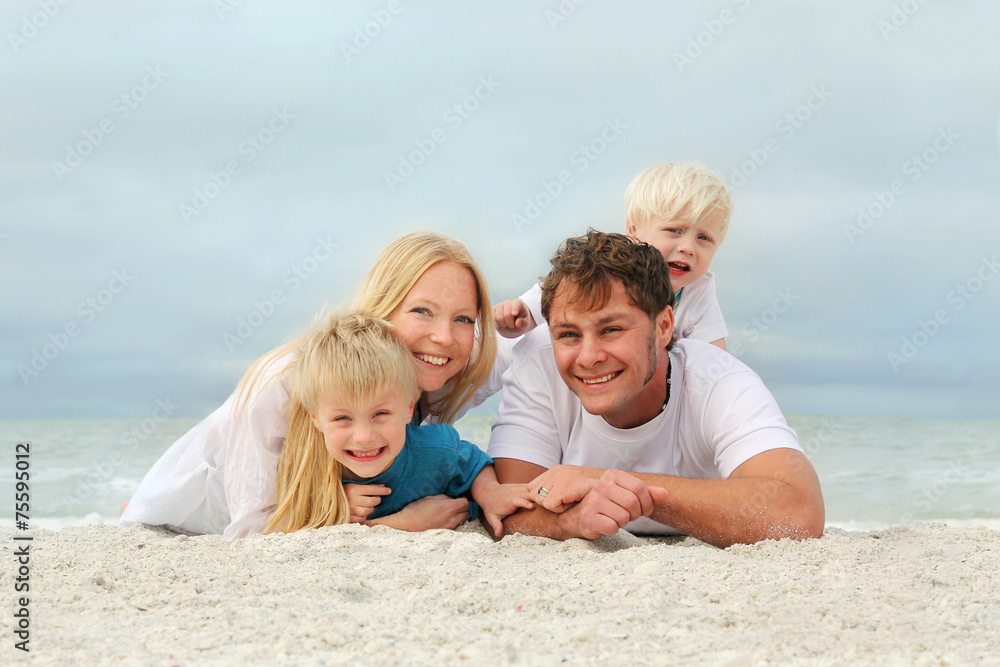 Portrait Of Happy Family of Four People Relaxing on the Beach Portrait Of Happy Family of Four People Relaxing on the Beach