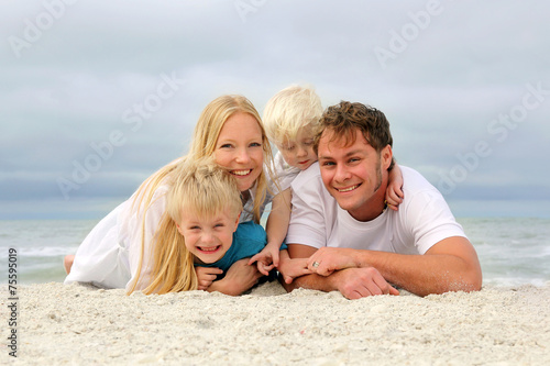 Portrait Of Happy Family of Four People Relaxing on the Beach