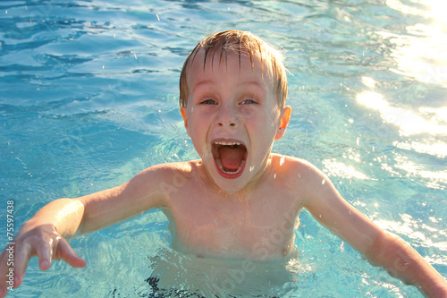 Very Excited Child Swimming in Pool photo