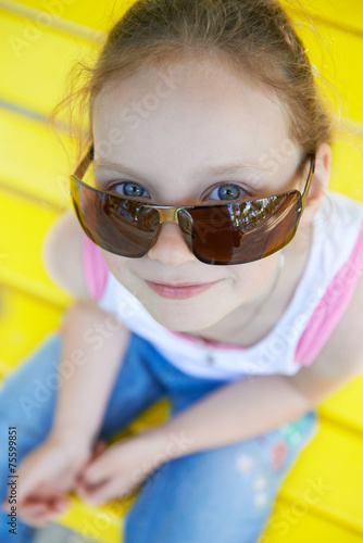 Adorable cute pretty little gir in sunglasses playing outdoors