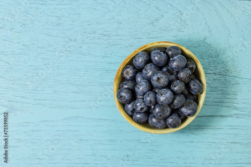 Blueberries in a bowl on a wooden table.