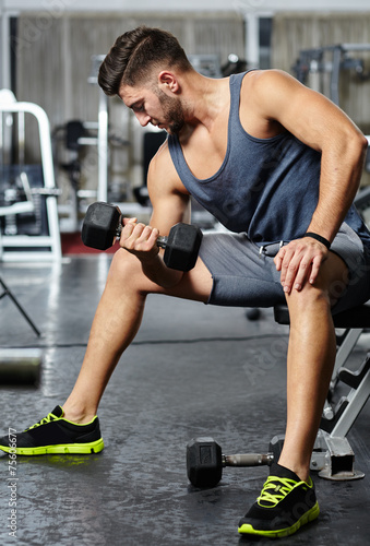 Fototapeta Naklejka Na Ścianę i Meble -  Man doing biceps workout in a gym
