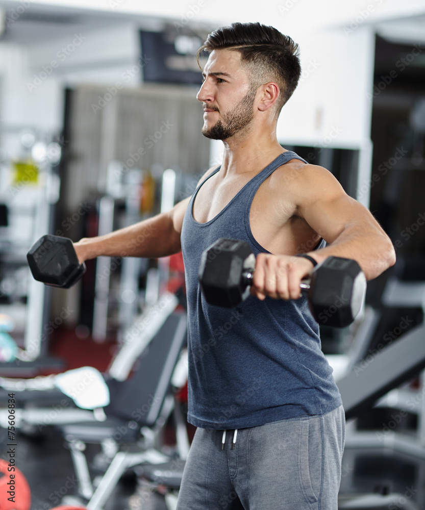 Man doing shoulder workout in a gym Man doing shoulder workout in a gym