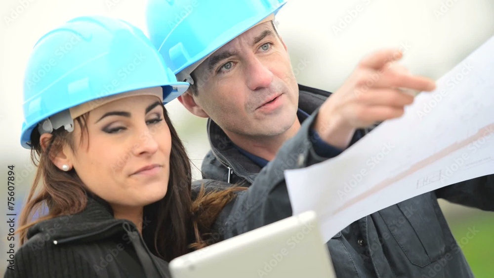 Architects on building site checking construction process Architects on building site checking construction process