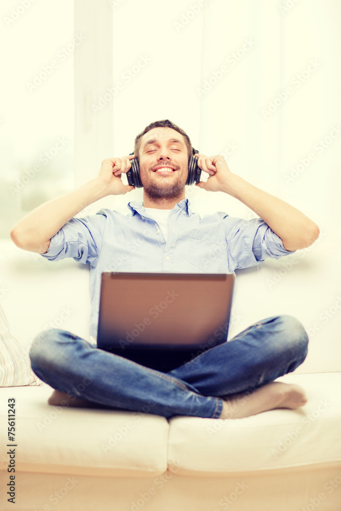 smiling man with laptop and headphones at home smiling man with laptop and headphones at home