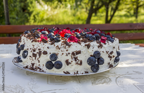 homemade cake topped with blueberries and pieces of red jelly photo