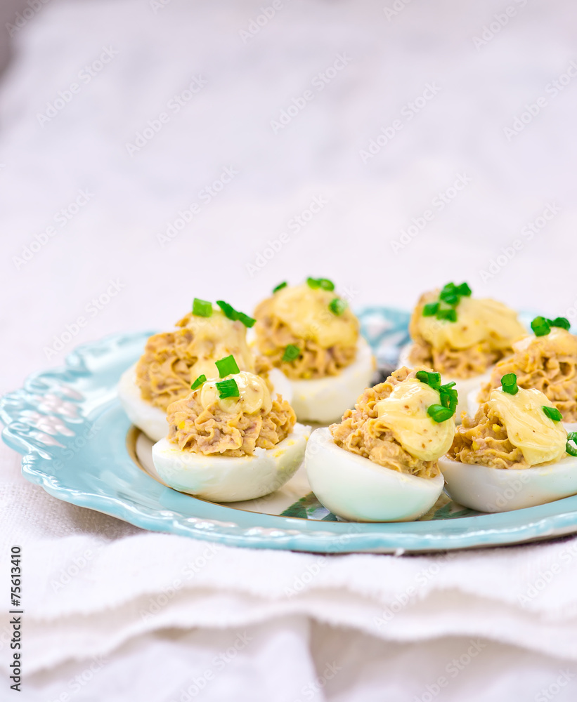 delicious stuffed eggs on blue plate.