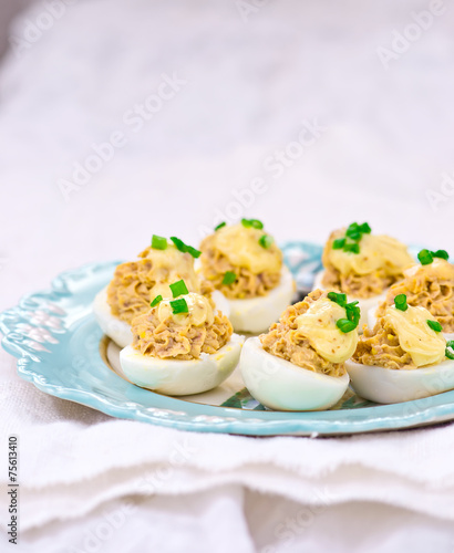 delicious stuffed eggs on blue plate.