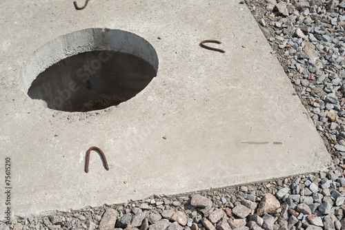 Manhole without cover in new concrete block photo