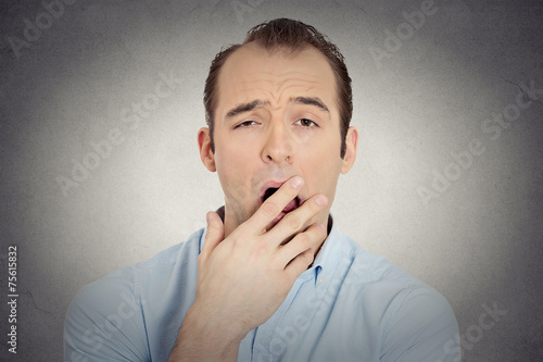 sleepy young businessman funny guy placing hand on mouth yawning