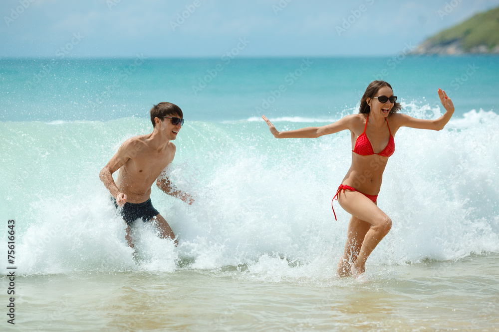 happy couple in sunglasses on the beach happy couple in sunglasses on the beach