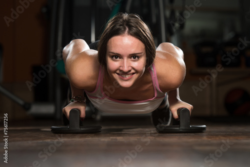 Young Woman Exercising Push Ups On Floor
