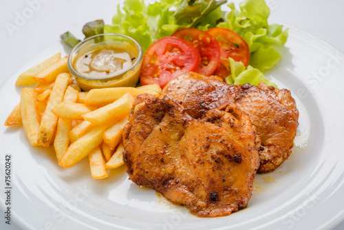 Chicken steak served with french fries and salads to vegetables