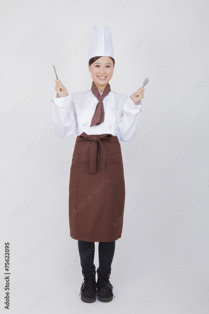 ナイフとフォークを持つ女性料理人