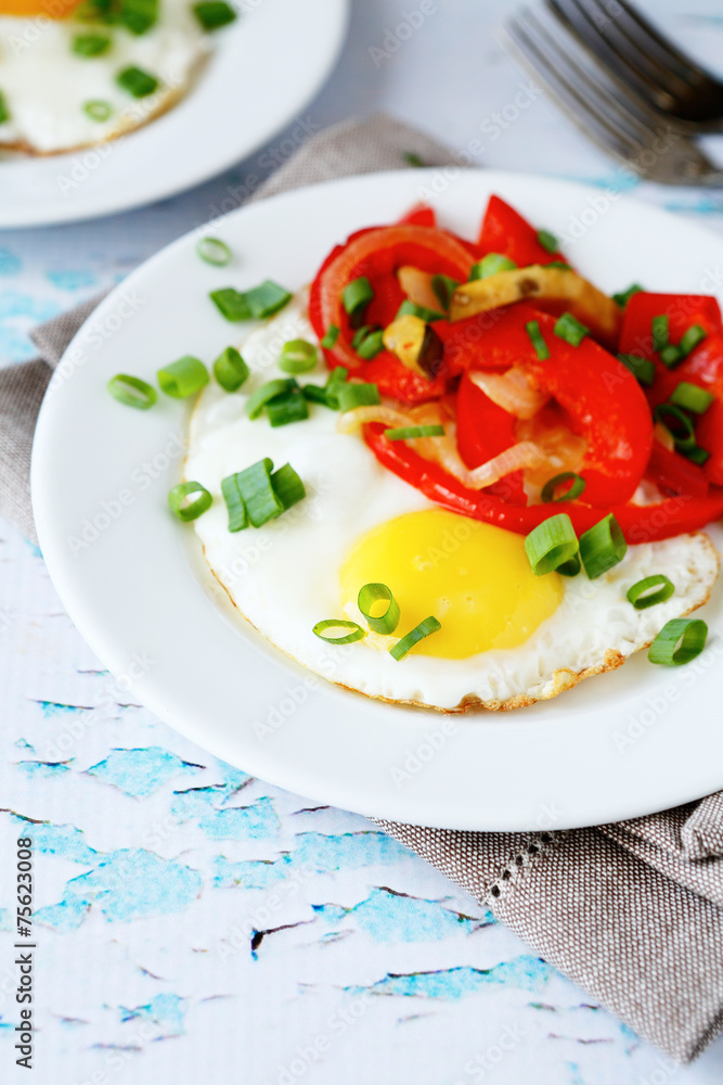 Fried eggs with peppers and onions in a bowl