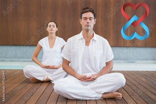 Peaceful couple in white sitting in lotus pose