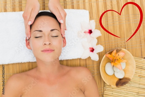 Composite image of smiling brunette enjoying a head massage