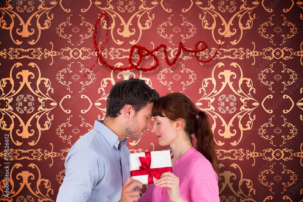 Composite image of loving couple holding a gift Composite image of loving couple holding a gift
