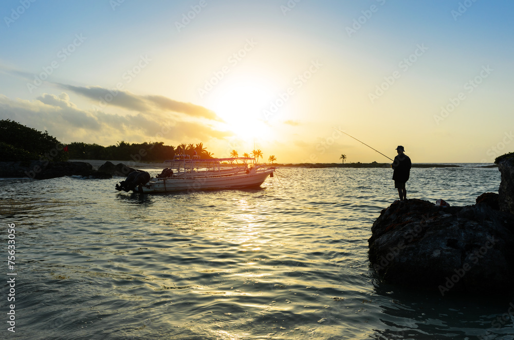Man fishing in the caribbean sea at sunrise