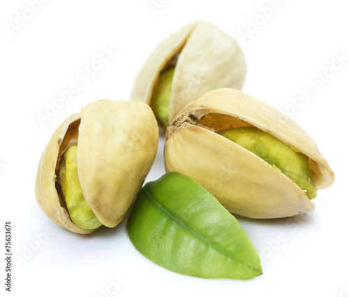 Three pistachio nuts with leaf