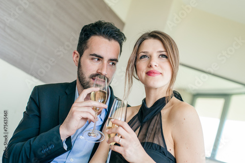 Elegant Young Couple Cheering at Hotel Suite