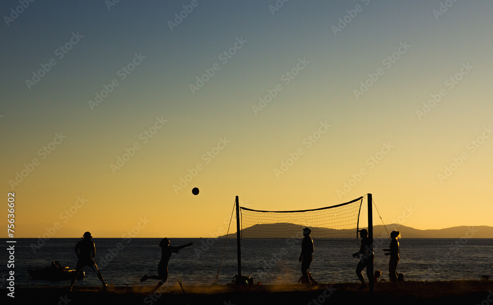 Beach volleyball at sunset.