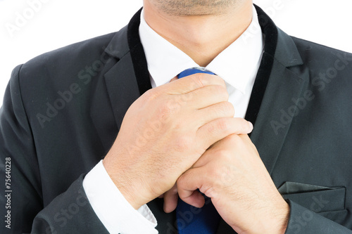 Businessman adjusting necktie isolated