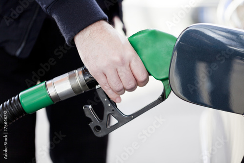 Pumping gas at gas pump. Closeup of man pumping gasoline fuel in © pawel70